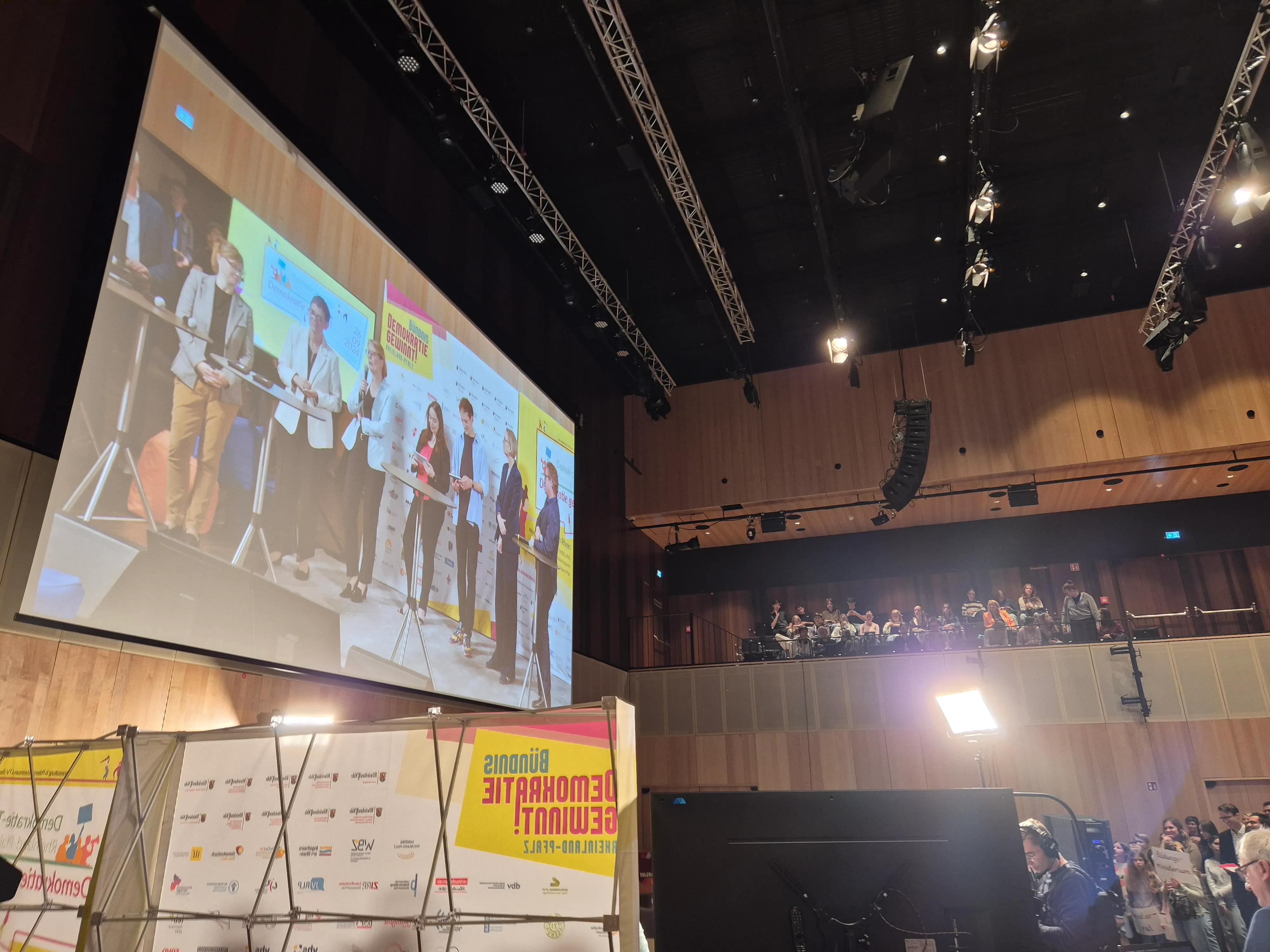 Eine Leinwand zeigt das Bühnenprogramm